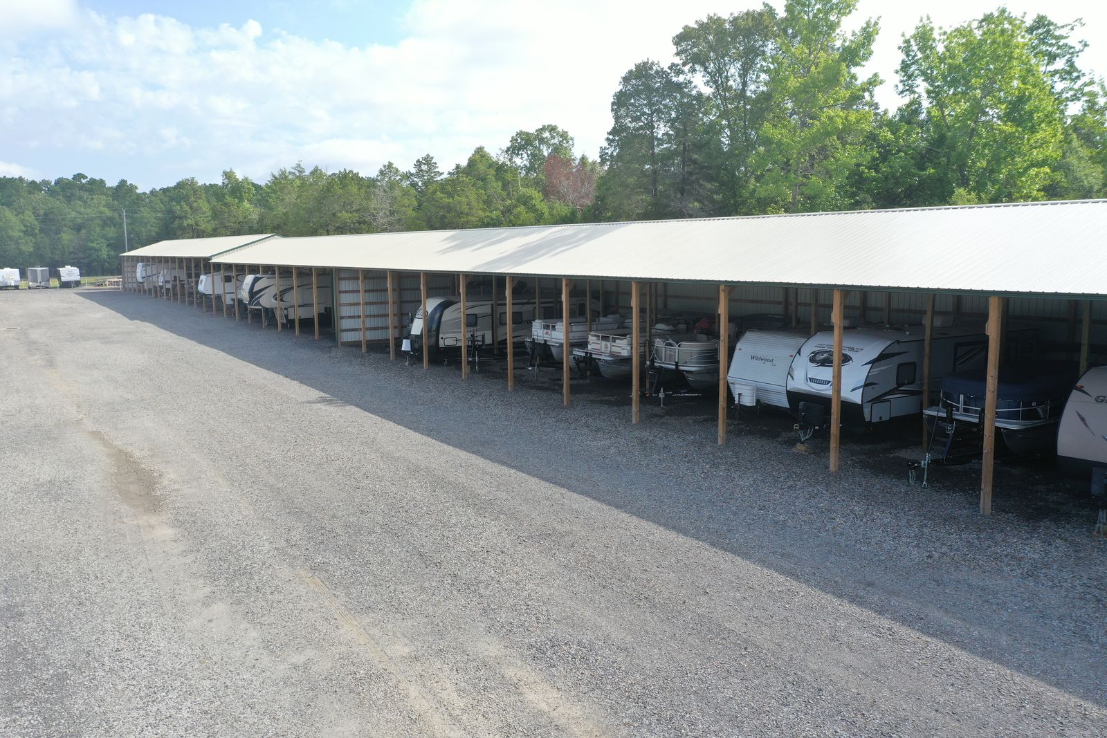 Covered RV and boat storage parking under open-sided shelter at Golden Anchor Storage